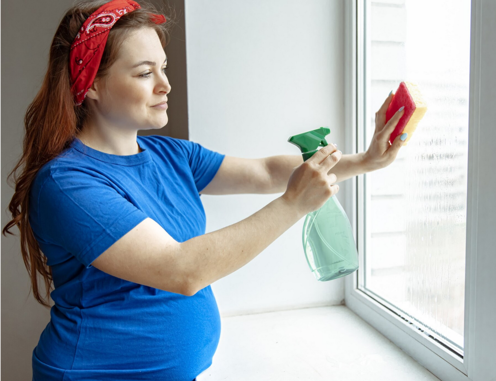 Une femme utilisant quel détergent pour nettoyer une fenêtre avec une éponge.