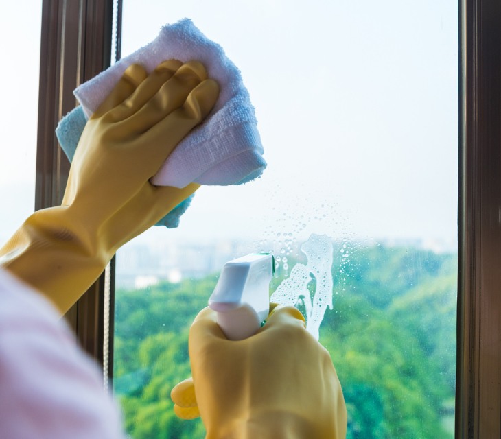 une personne utilisant de la mousseline pour nettoyer une fenêtre.